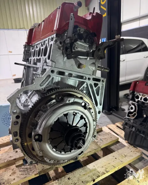 A clutch cover and flywheel exposed on an engine lifted out of the car