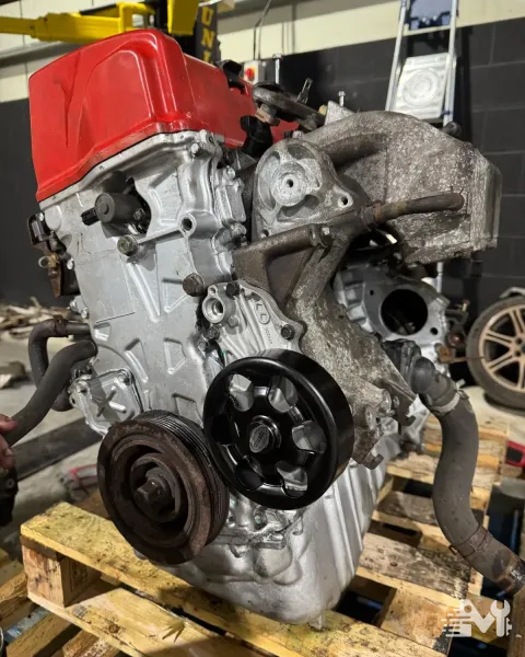 An engine and gearbox bellhousing out of the vehicle and stood on a pallet