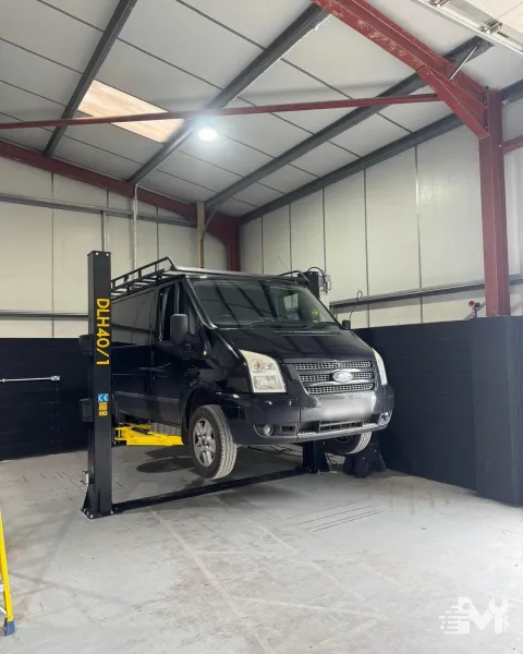 A Ford Transit up on the two post lift for an MOT check over