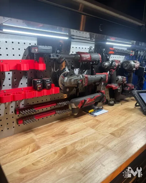 The workshop tool wall, with cordless impact guns, grinders and sockets on the board