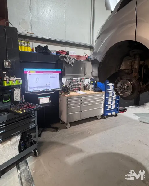 A manufacturer wiring diagram on the workshop screen while a van is worked on behind