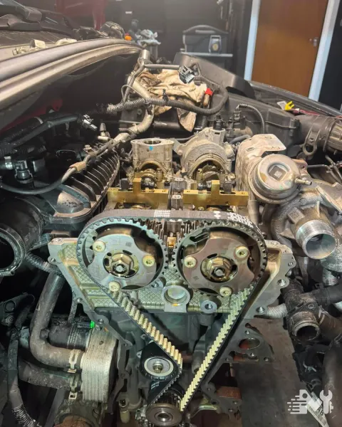A cam belt change in progress, with the camshaft locking tools fitted