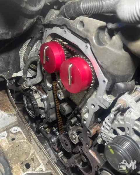 Camshaft locking tools clamped to the pulleys while a new timing belt is fitted