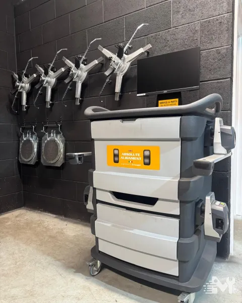 The four wheel alignment cabinet and its wheel clamps stored on the workshop wall